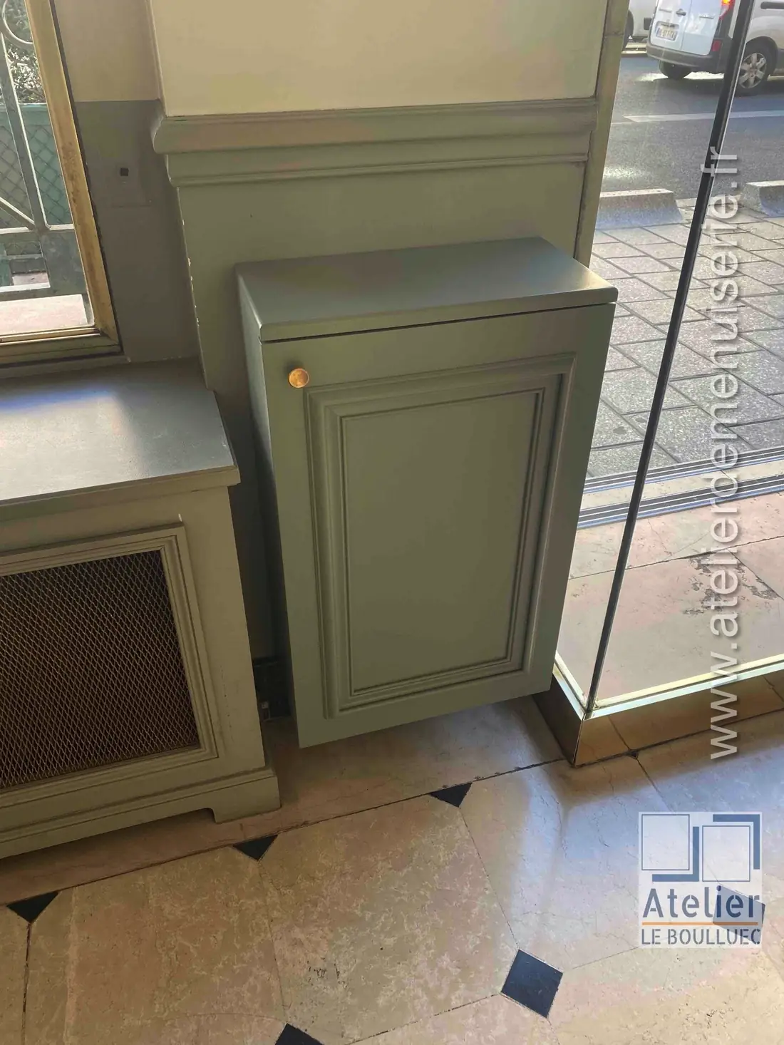 Petit meuble peint vert-de-gris à moulures en applique, avec cache-radiateur en cannage