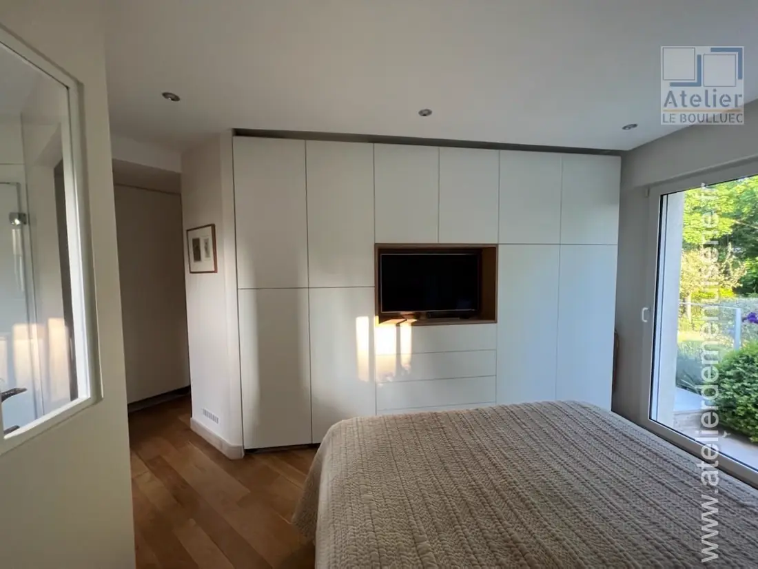 Chambre avec tête de lit laquée blanche intégrant une niche pour téléviseur