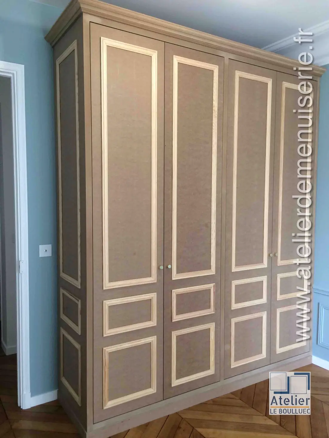 Placard à trois portes ornées de moulures en applique, dans une chambre à parquet point de Hongrie
