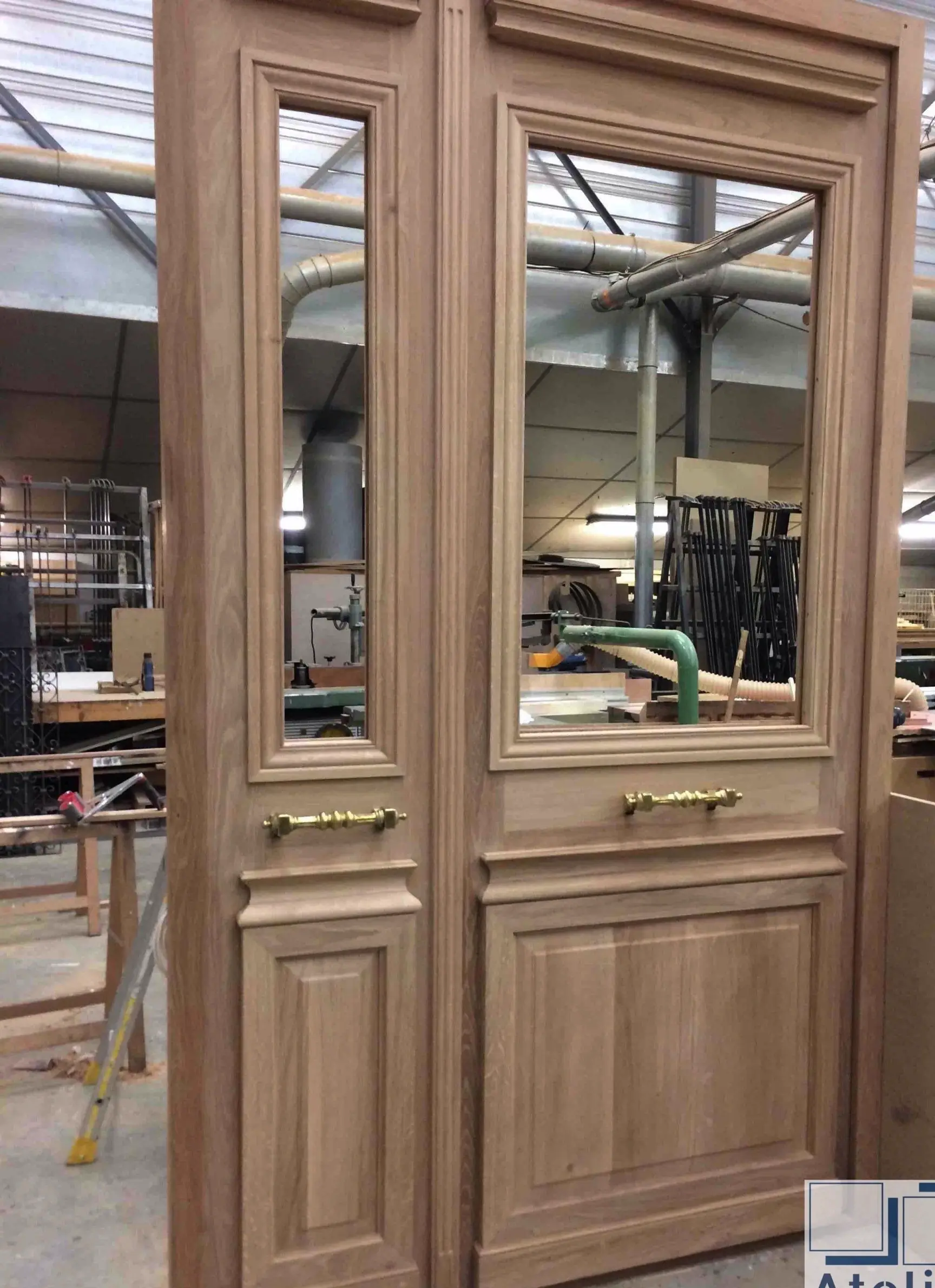 Porte à deux vantaux en chêne montée à blanc sur les établis de l’atelier