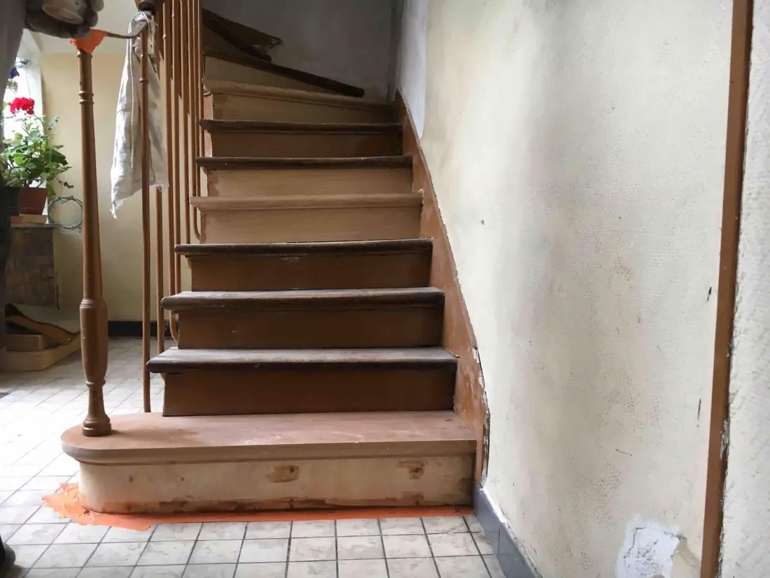 Escalier ancien en chêne restauré dans une maison, marches et contremarches reprises