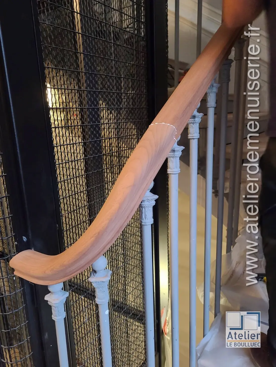 Main courante en bois débillardée suivant la courbe d’un escalier à balustres