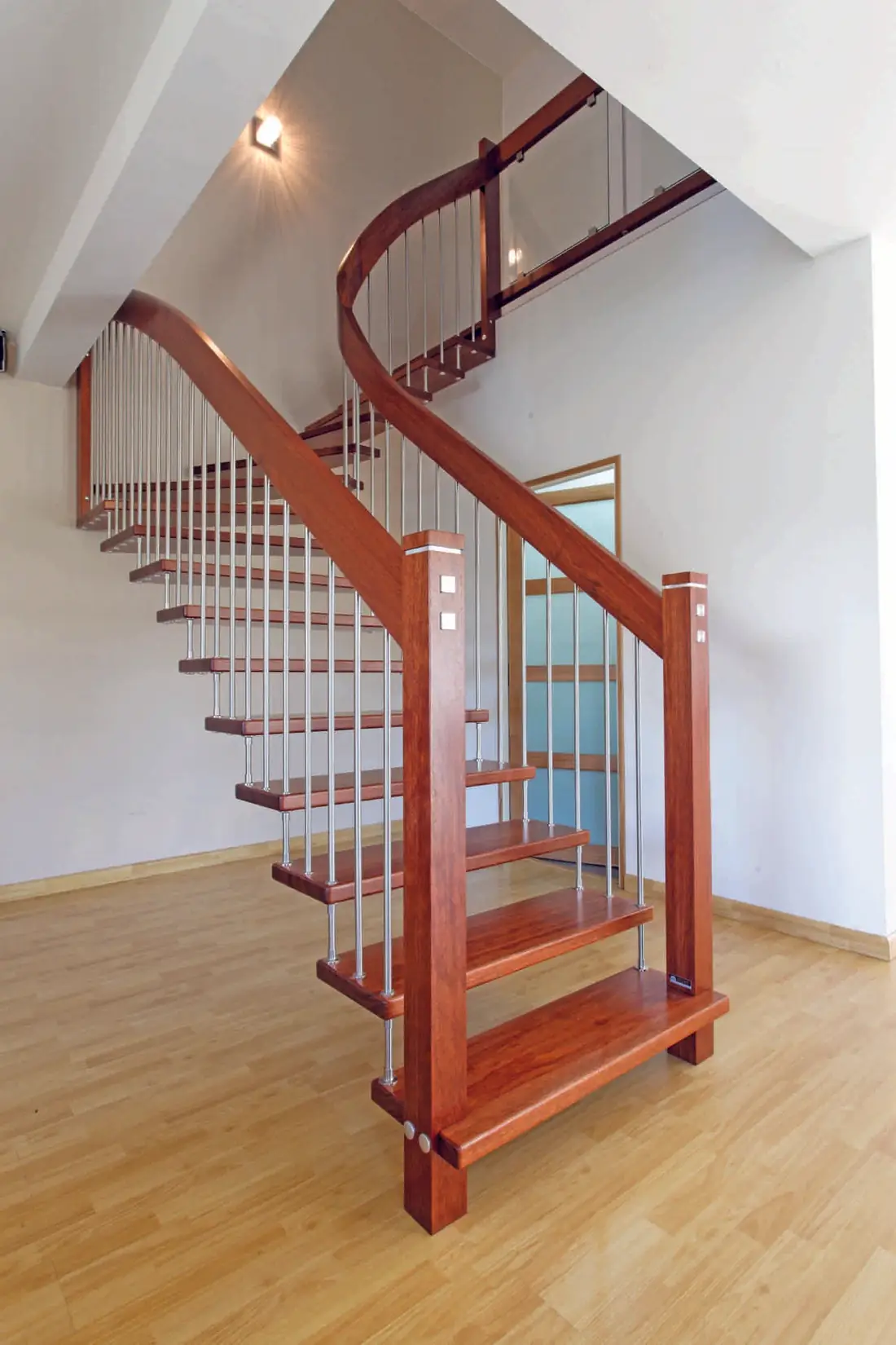 Escalier hélicoïdal en bois vernis rouge à balustres inox