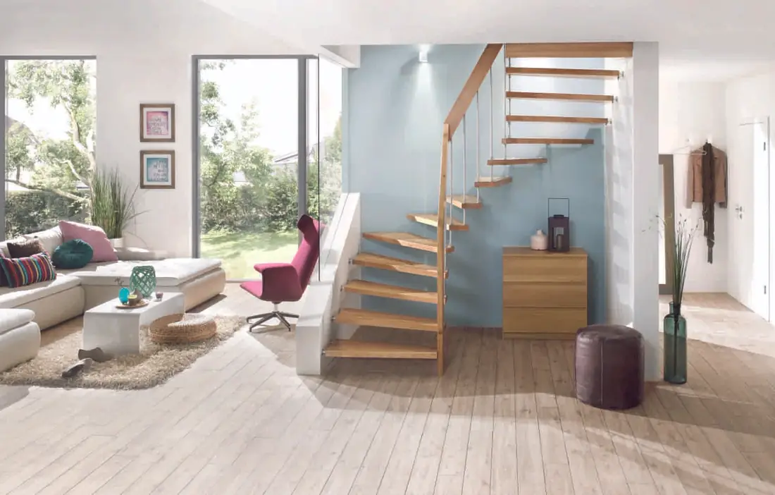 Escalier en bois à limon central et balustres inox, dans un séjour ouvert sur le jardin