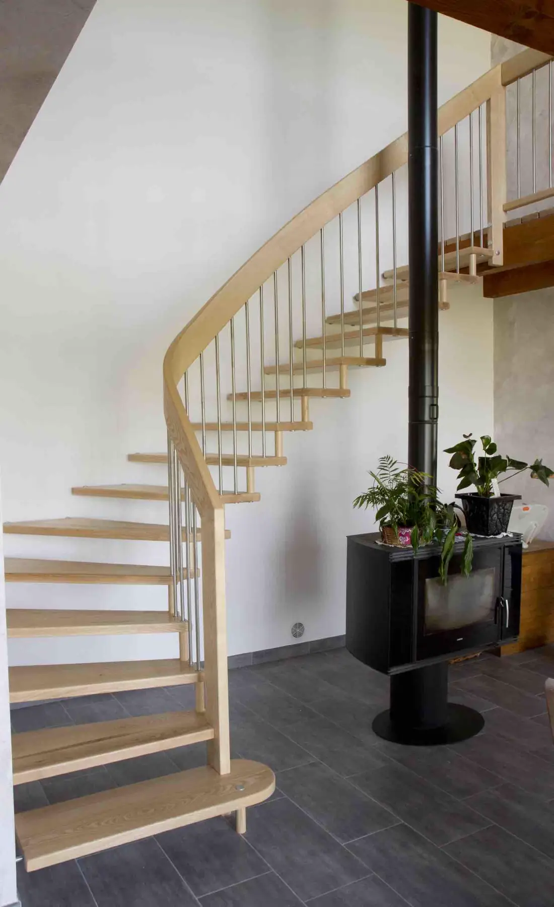 Escalier hélicoïdal en bois tournant autour d’un poteau en acier