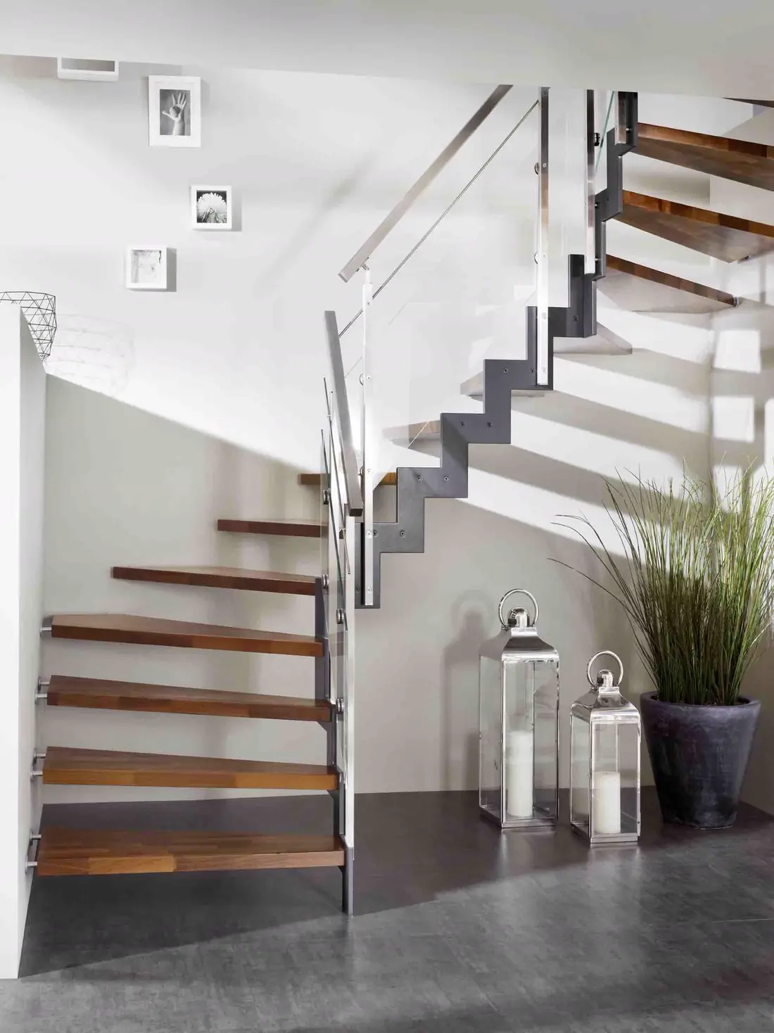 Escalier à limon acier en deux volées, marches en bois foncé et main courante inox
