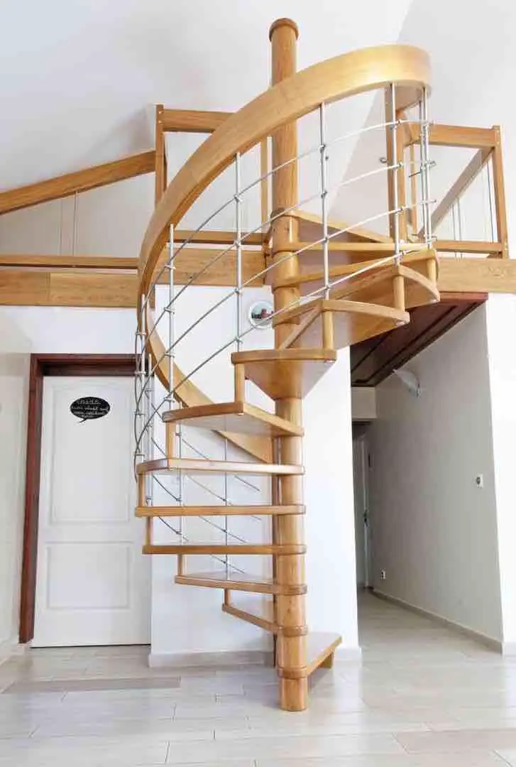 Escalier hélicoïdal en bois à balustres inox, dans une cage blanche