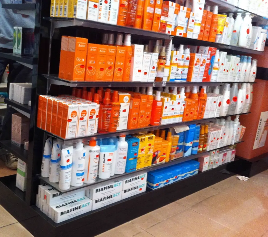 Rayonnages noirs garnis de boîtes dans une officine de pharmacie