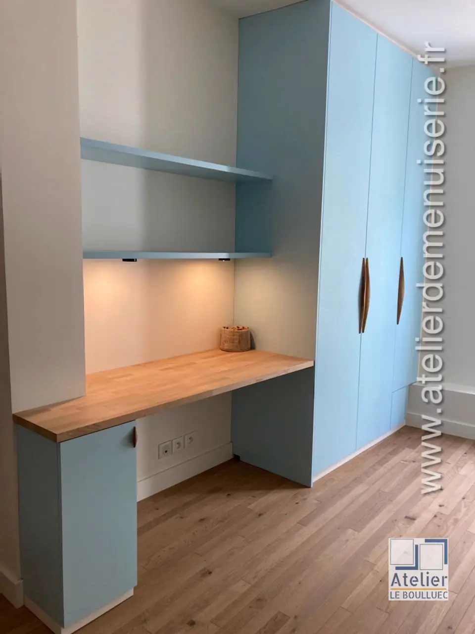 Plan de bureau en chêne et armoire laquée bleu clair aménagés dans un angle