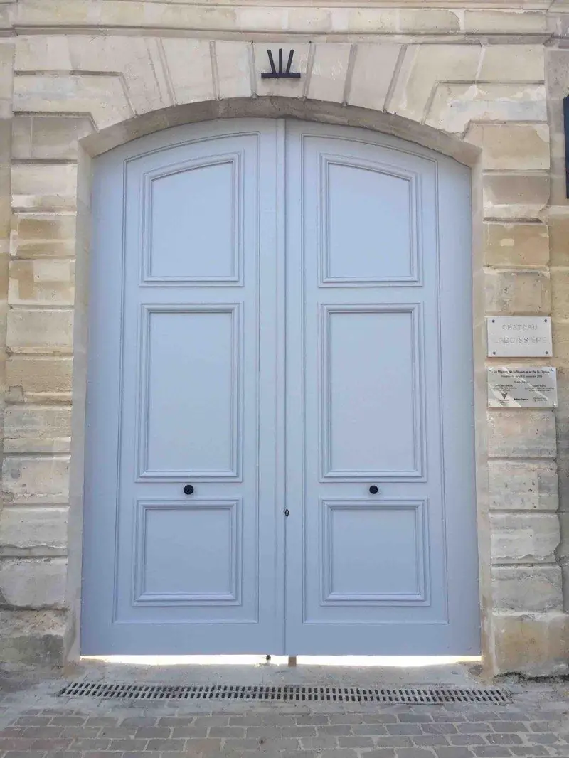 Porte cintrée gris clair du château Laboissière, encadrement de pierre