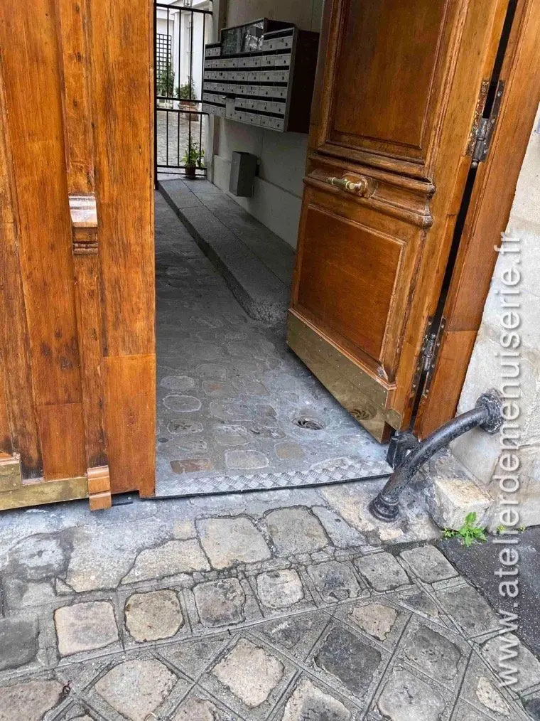 Pied de vantail et chasse-roue en fonte au ras du pavé, après repose