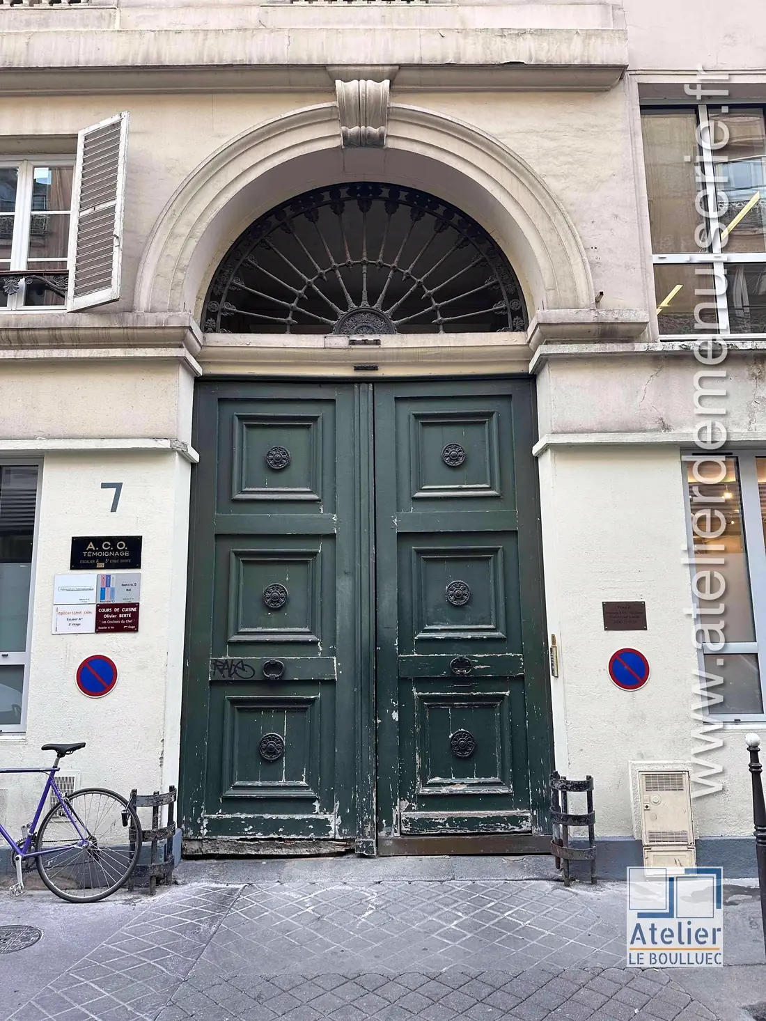 Porte cochère vert sombre sous un arc plein cintre à imposte en éventail, avant travaux