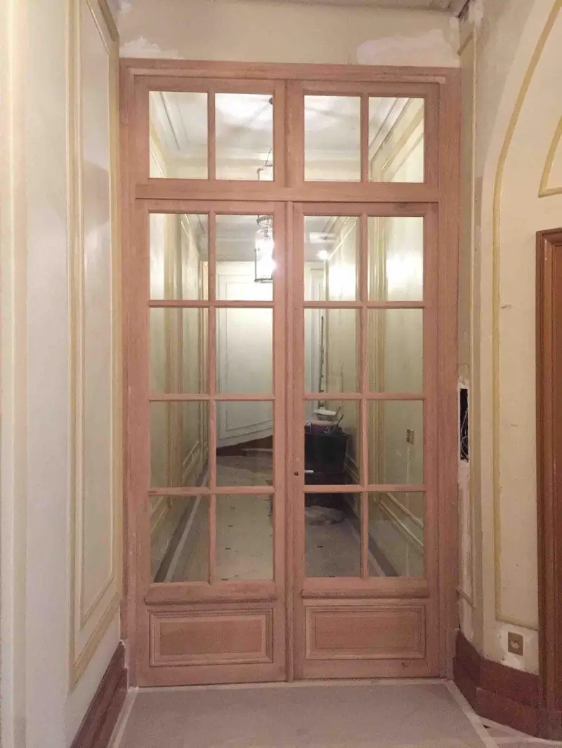 Porte sas vitrée à petits bois en chêne, dans le hall d’un immeuble