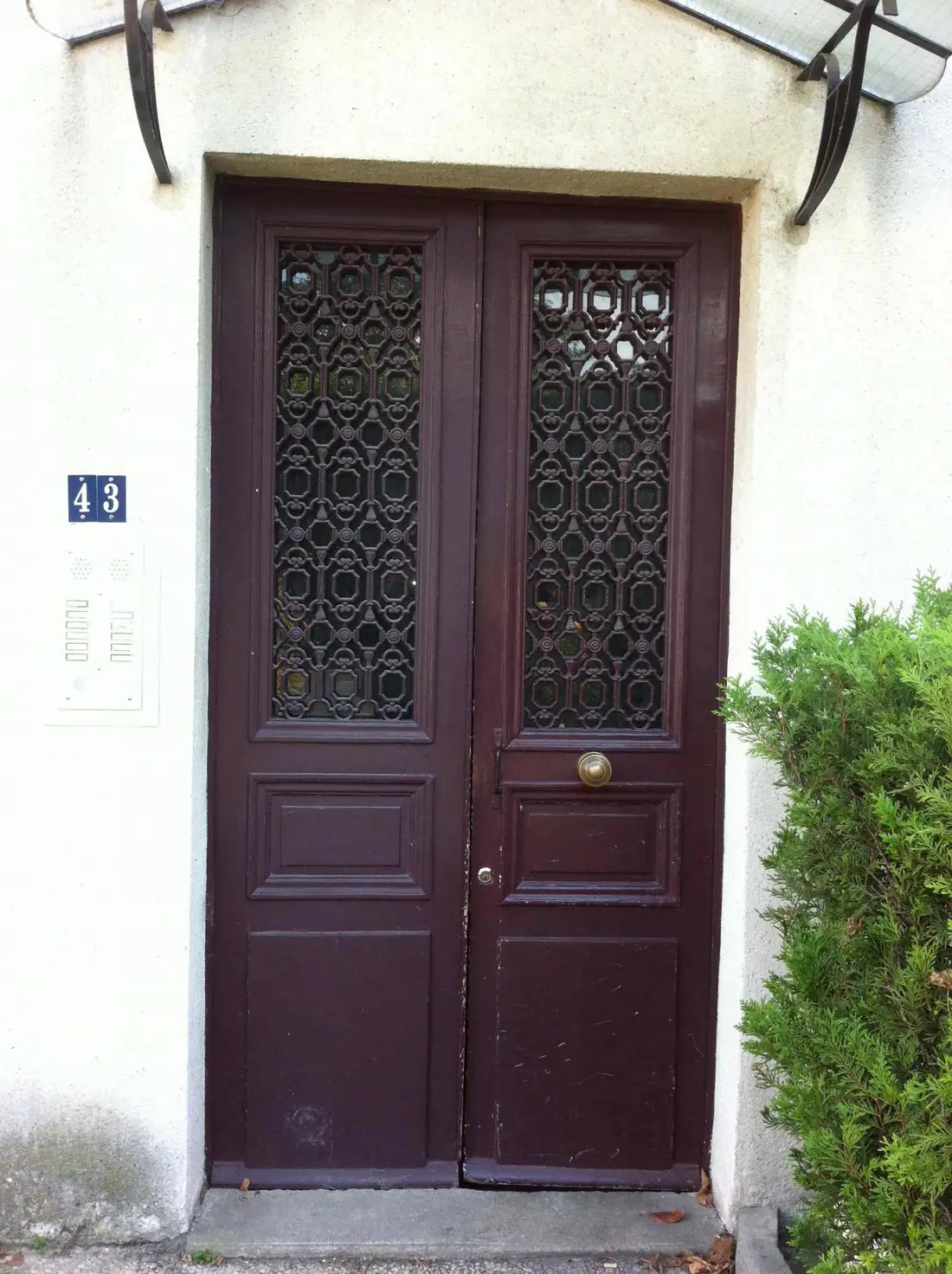 Porte à deux vantaux teintée lie-de-vin, grilles ouvragées et numéro 43