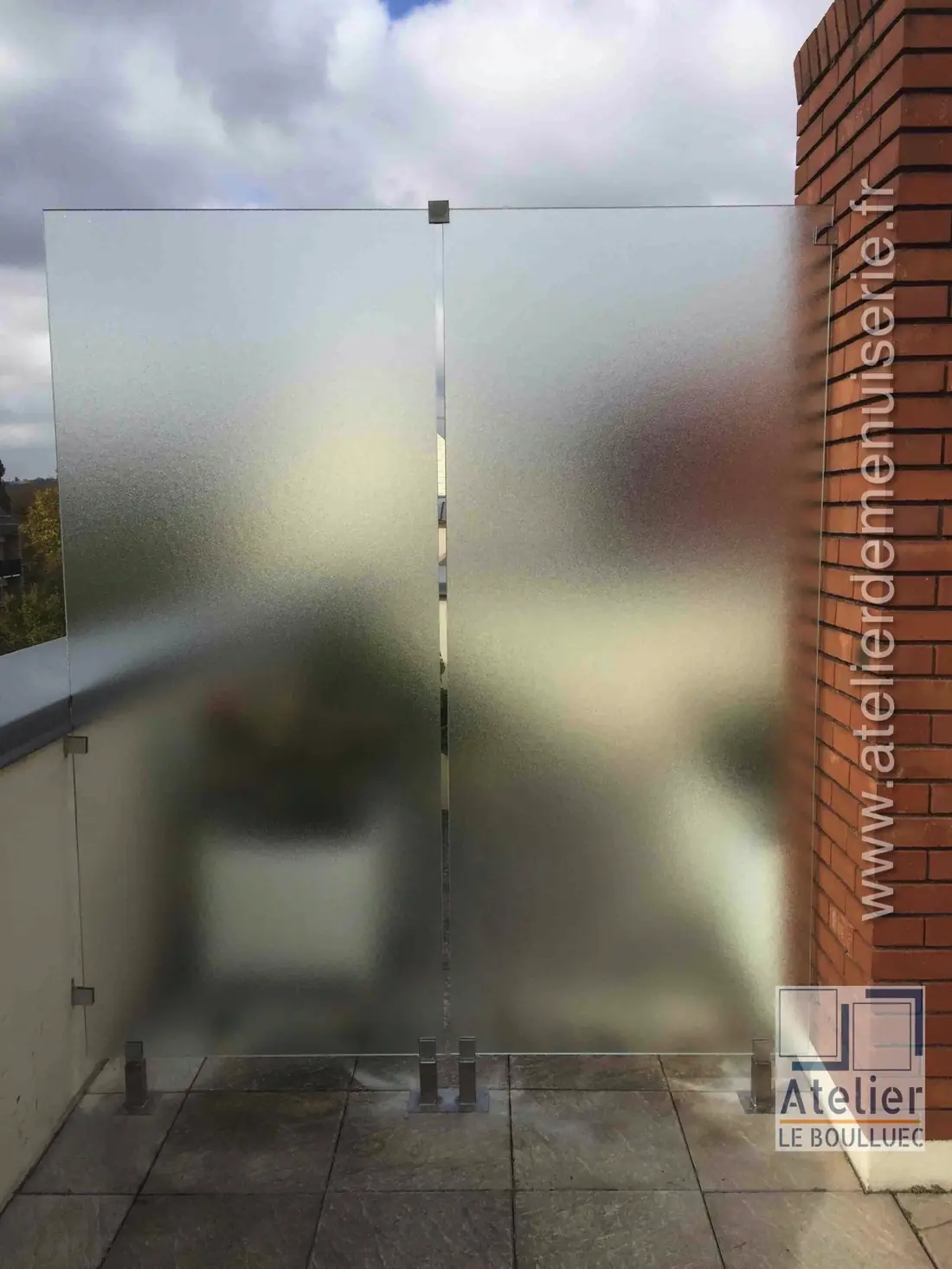 Cloison séparative en verre dépoli montée sur une terrasse