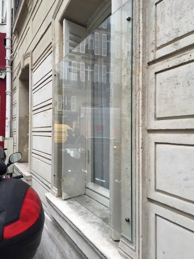 Vitrage de protection posé devant une porte ancienne donnant sur la rue